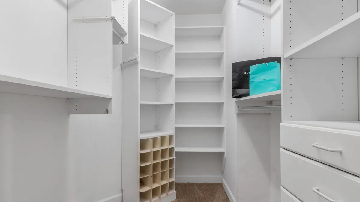 White walk-in closet with shelves and drawers
